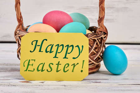 Happy Easter card, colorful eggs. Greeting card on white wood.
