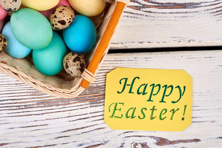 Easter basket, top view. Yellow greeting card on wood.