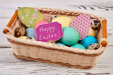 Easter basket on wooden backgorund. Patterned egg cutouts.の写真素材