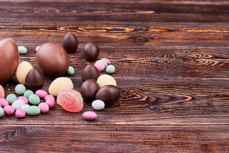 Sweets on brown wood. Candies and chocolate eggs. Confectionery to make at home.の写真素材