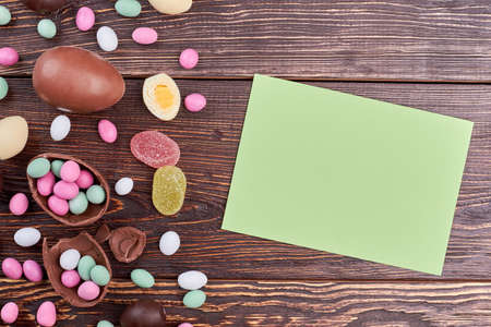Sweets and card with copyspace. Scattered candies on wood.の写真素材