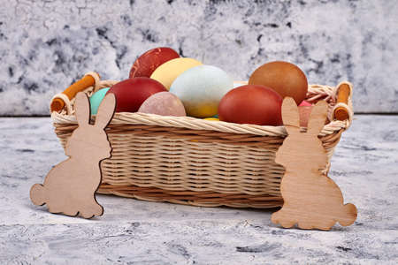 Easter basket and plywood rabbits. Dyed eggs pile.の写真素材