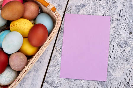 Easter egg basket, empty card. Blank paper, wooden background. Easter party invitation template.の写真素材