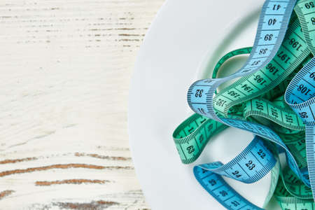 Measuring tape on a plate. Strategy for getting healthy.の写真素材