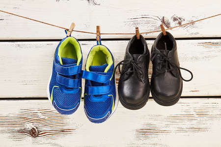 Shoes hanging on clothesline. How to dry wet footwear.の写真素材