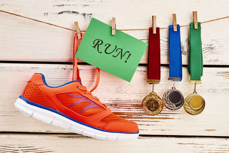 Medals, card and sneaker. Sports achievements motivation.の写真素材