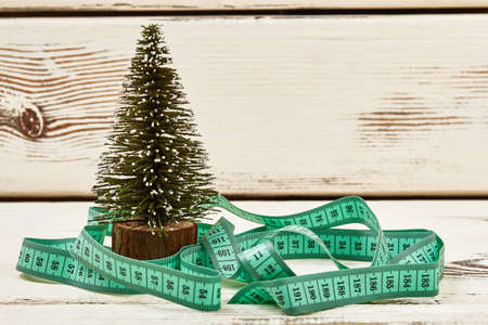 Christmas tree and measuring tape. New year motivation.の写真素材