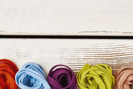 Multicolored shoelaces on wooden background. Stylish footwear accessories.の写真素材