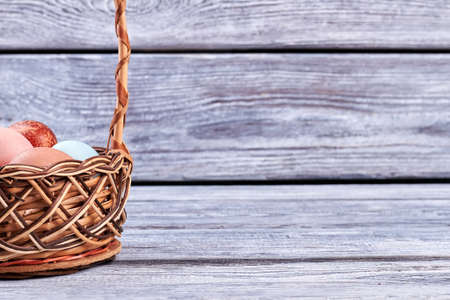 Basket of eggs on wood. Easter wicker basket.