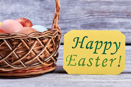 Happy Easter greeting card. Wicker basket with eggs.
