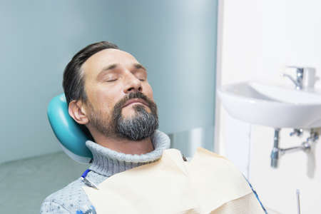 Person in dentist office. Mature mand with closed eyes.の写真素材