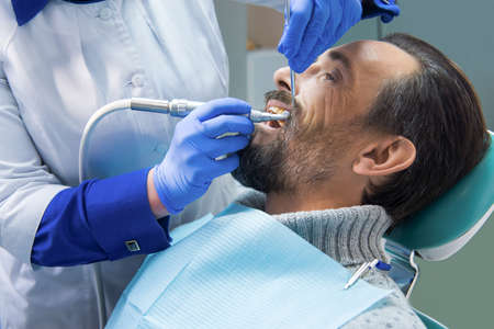 Dentist at work. Patient in dental chair.の写真素材