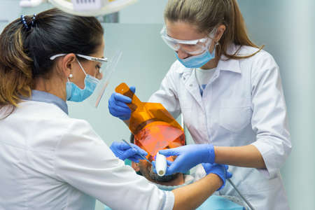 Dental doctors working. UV light and safety glasses.の写真素材