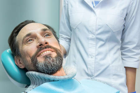 Mature male at the dentist. Patient of stomatologist. Health insurance tips.の写真素材