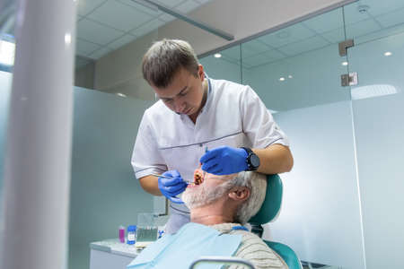 Stomatologist with senior patient. Person at the dentist office.の写真素材
