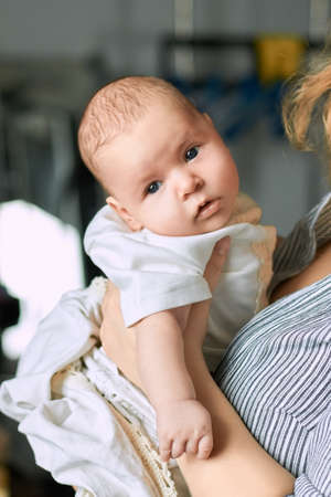 Hand of woman holding baby. Small caucasian child.