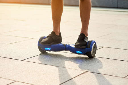 Legs of man on hoverboard. Person riding blue gyroboard. Best self balancing scooters.の写真素材