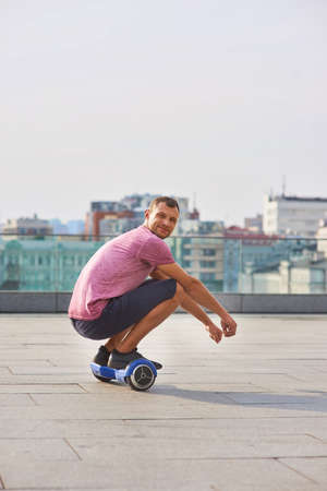 Young man riding hoverboard. Guy on urban background.の写真素材