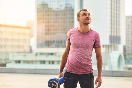 Young man holding gyroscooter. Guy looking up. The world is developing.の写真素材