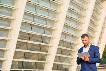 Young businessman using tablet. Caucasian guy in a suit.の写真素材