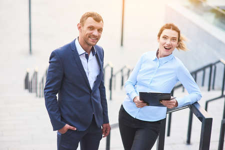 Young business couple with clipboard. Smiling man and woman. Advice for recruiters.