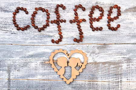 Coffee beans and cardboard. Grain, beige heart, wooden background. Coffee make romantic.の写真素材