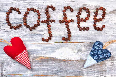 Heart from textile and coffee. Coffee grain on wooden background.の写真素材