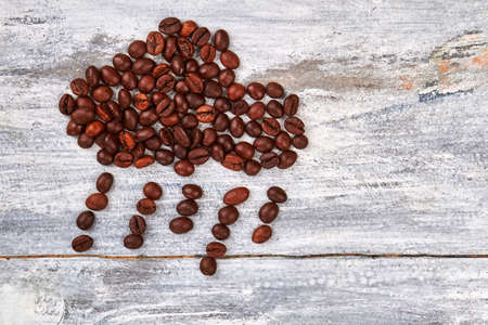 Rain from coffee beans. Coffee grain on wooden background. Coffee give warm.