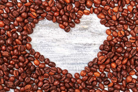 Heart from coffee beans. Coffee grain, wooden space.の写真素材