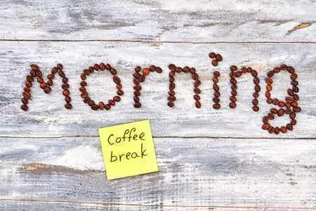 Title morning on wooden background. Coffee grain and message.の写真素材