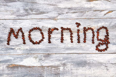 Morning made from coffee beans. Coffee text on wooden background.の写真素材