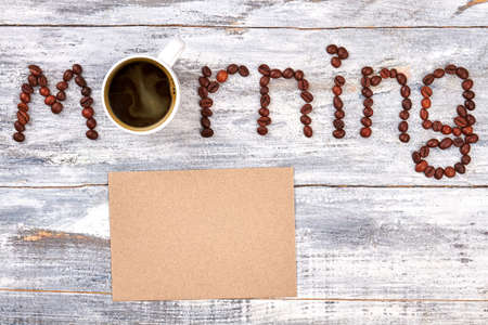 Porcelain cup with dark coffee. Paper, word from coffee grain.の写真素材