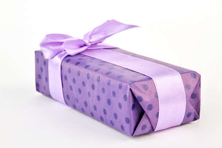 Present wrapped in purple box. Violet box with satin bow, white background. Nice present for festive.の写真素材