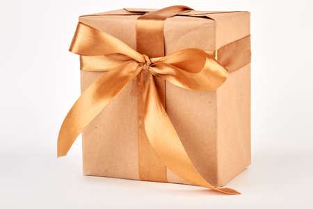 Gift box with golden ribbon. Paper box with bow, white background.の写真素材