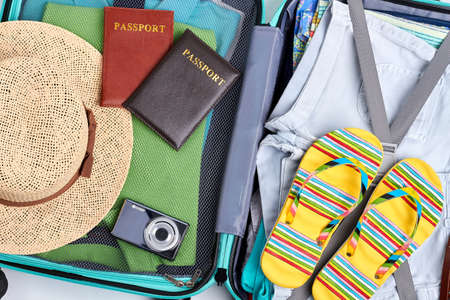 Luggage with accessories close up. Beach clothes and passports.の写真素材