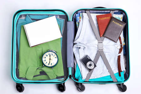 Open traveler suitcase close up. Man and woman clothes in luggage.の写真素材