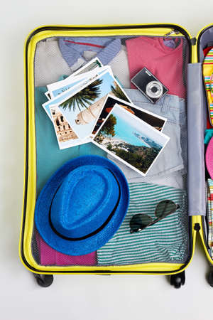 Yellow suitcase with man accessories. Bright things for summer resort.