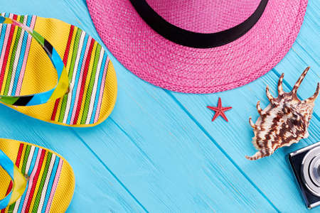 Close up of summer beach stuff. Slippers, hat, seashells, camera. Concept of summer travel.の写真素材