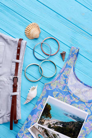 Set of clothes and accessories. Photos of resorts, shorts, shirt, wristlets, seashells. Concept of...