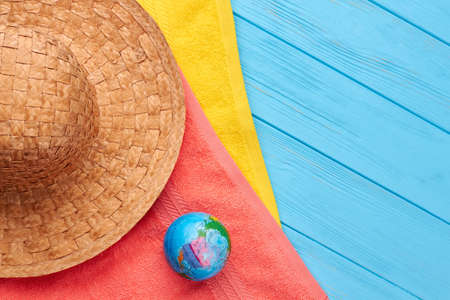 Hat, towels, globe, sea background. Summertime beach objects, vintage background.の写真素材