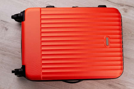 Red traveler suitcase close up. Modern wheeled luggage for travelling abroad.の写真素材