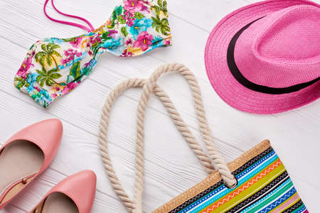 Collection of women beach accessories. Summer fashion look, wooden background.