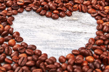Heart image from coffee beans. Coffee heart on wooden surface.の写真素材