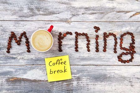 Coffee drink among coffee letters. Note on wooden background.の写真素材