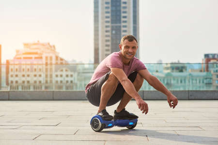 Smiling man on hoverboard. Guy in the city.の写真素材
