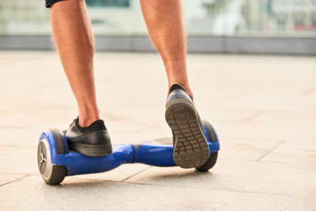Legs and hoverboard. Person on self balancing scooter.