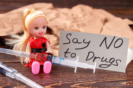 Syringes, doll, message on blurred background. Say no drugs and harmful habits.の写真素材