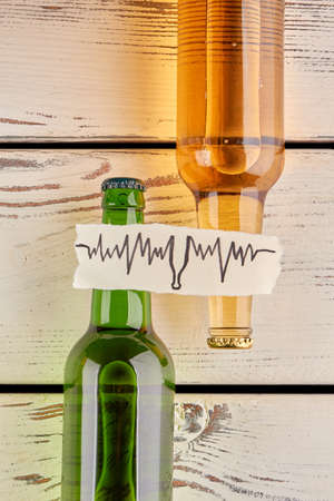 How alcohol affects your body. Vertical image of bottles with beer, wooden background.