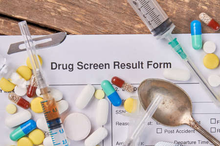 Drug screen result form, syringes, spoon. Result of drugs overdose.の写真素材