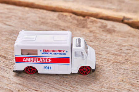 Emergency ambulance on wooden background. Medical service car on blurred background.の写真素材